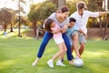 Family Playing Soccer In Park Together