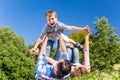 Family playing with son lying in grass on meadow Royalty Free Stock Photo