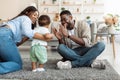 Cute baby toddler walking in living room playing with parents Royalty Free Stock Photo