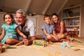 Family playing with toys in an attic playroom, portrait Royalty Free Stock Photo