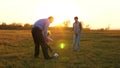 Family playing with younger baby with soccer ball in the park at sunset. Happy dad and child kick ball. happy family Royalty Free Stock Photo