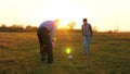 Family playing with younger baby with soccer ball in the park at sunset. Happy dad and child kick ball. happy family Royalty Free Stock Photo