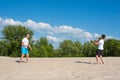 The family plays beach badminton. Father and son play badminton on the beach