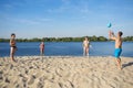 The family plays beach volleyball on the sandy shore of the river. A healthy way of life