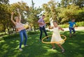 A family that plays together stays together. A happy family hula hooping in the park on a sunny day.