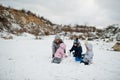 Family plays in winter outdoor, mother and children having fun