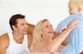 Family playtime. Two parents playing lovingly with their young son on their bed. Royalty Free Stock Photo