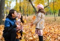 Family portrait in an autumn park. Happy people playing with fallen yellow leaves Royalty Free Stock Photo