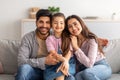 Family portrait. Excited arabic parents and cute little daughter posing together, embracing and smiling to camera Royalty Free Stock Photo