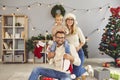 Family portrait of happy mom, dad and their little son looking at camera during Christmas photoshoot Royalty Free Stock Photo