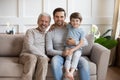 Family portrait happy three generations of men sitting on couch Royalty Free Stock Photo