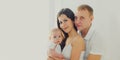 Family portrait happy young mother and father with baby at home in white room Royalty Free Stock Photo