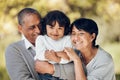 Family, portrait and hug by child and grandparents in a park with care, bond and fun on blurred background. Love, smile