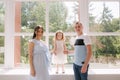 Family portrait of mom dand and little daughter in front of big window. Happy family Royalty Free Stock Photo