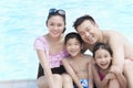 Family portrait, mother, father, daughter, and son, smiling by the pool