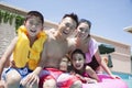 Family portrait, mother, father, daughter, and son, smiling by the pool Royalty Free Stock Photo