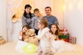 Family portrait - parents and children in home interior decorated with holiday lights and gifts Royalty Free Stock Photo