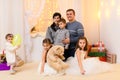 Family portrait - parents and children in home interior decorated with holiday lights and gifts Royalty Free Stock Photo