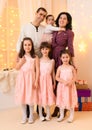 Family portrait of a parents and children in home interior decorated with lights and holiday gifts Royalty Free Stock Photo