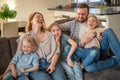 family portrait. family photo in which mom, dad, daughters, son and dog are smiling and hugging on the couch in a cozy Royalty Free Stock Photo