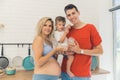 family portrait - pregnant mother, father and their little son standing in the kitchen, happy famile relatiosnhip