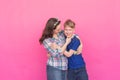 Family portrait sister and teenager brother on pink background