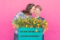 Family portrait sister and teenager brother with tulips on pink background