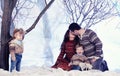 Family portrait sits on studio snow forest background Royalty Free Stock Photo