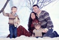 Family portrait sits on studio snow forest background Royalty Free Stock Photo