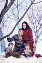 Family portrait sits on studio snow forest background Royalty Free Stock Photo