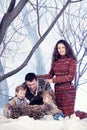 Family portrait sits on studio snow forest background Royalty Free Stock Photo