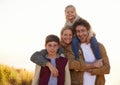 Family, portrait and smile with field, walk and sunrise for morning exercise and bond. Parents, children and countryside Royalty Free Stock Photo