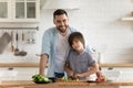 Family portrait smiling father and little son cooking dinner together