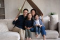 Family portrait smiling parents with kids sitting under cardboard roof