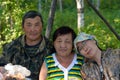 Family portrait of two elderly and one young daughter Yakut Asians in the Northern forest