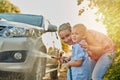 Family, portrait and washing car with water in driveway for bonding, chores or responsibility. Happy, love or smile with Royalty Free Stock Photo