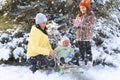family portrait in the winter forest, mother and children sitting and playing with snow, beautiful nature with snowy fir trees Royalty Free Stock Photo