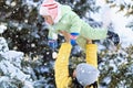 Family portrait in the winter forest, mother lift the baby up in her arms, bright snowy fir trees, beautiful nature