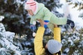 Family portrait in the winter forest, mother lift the baby up in her arms, bright snowy fir trees, beautiful nature