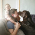 Young caucasian father with cute smiling little baby girl sitting on his shoulders and pet labrador retriever Royalty Free Stock Photo