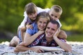 Family portrait of young happy mother, father and two cute blond children, boy and girl on bright summer day with green bokeh Royalty Free Stock Photo