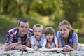 Family portrait of young happy mother, father and two cute blond children, boy and girl on bright summer day with green bokeh Royalty Free Stock Photo