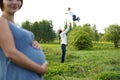 Family. Family Portrait. Young happy Family walking outdoor. Pregnant woman, husband and Child. Dad throws his son up in