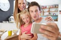 Family Posing For Selfie At Breakfast Table