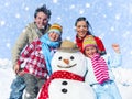 Family Posing With A Snowman Outdoors