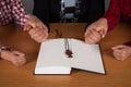 Family praying at home, wooden table. Wooden cross Royalty Free Stock Photo