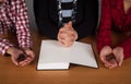 Family praying at home, wooden table. Wooden cross Royalty Free Stock Photo