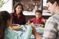 Family Praying Before Meal Around Table At Home