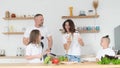 The family prepares a healthy dinner and has fun in the kitchen, dancing to music Royalty Free Stock Photo