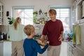 Family preparing breakfast together in home kitchen. Healthy breakfast or snack before kindergarden, school and work. Royalty Free Stock Photo